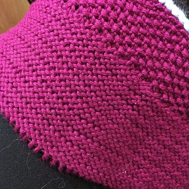 Stockinette fabric showing rowing out with uneven purl ridges on the back side.
